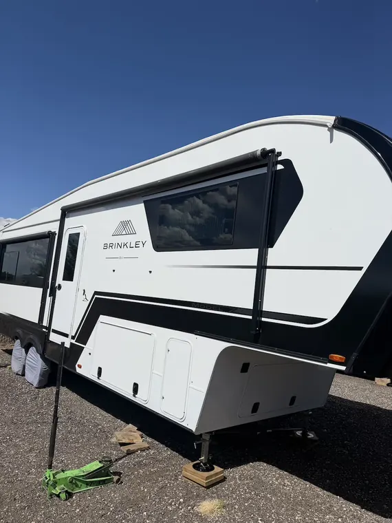 Brinkley fifth wheel on site with the awning arm extended