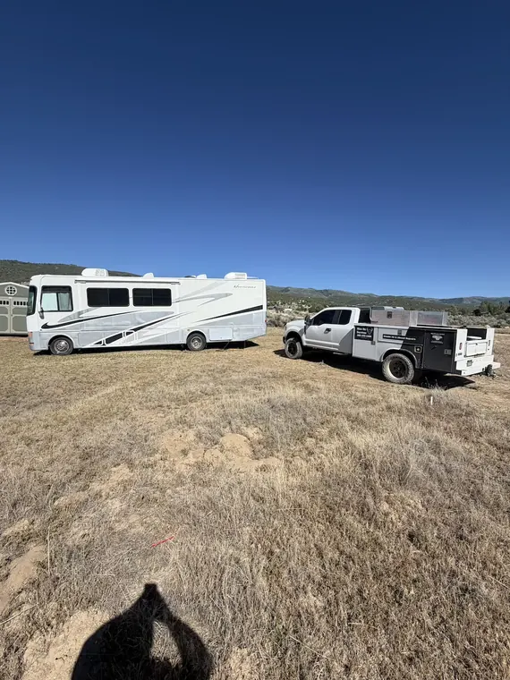Mobile service call out in an open field, motorhome and service truck side by side