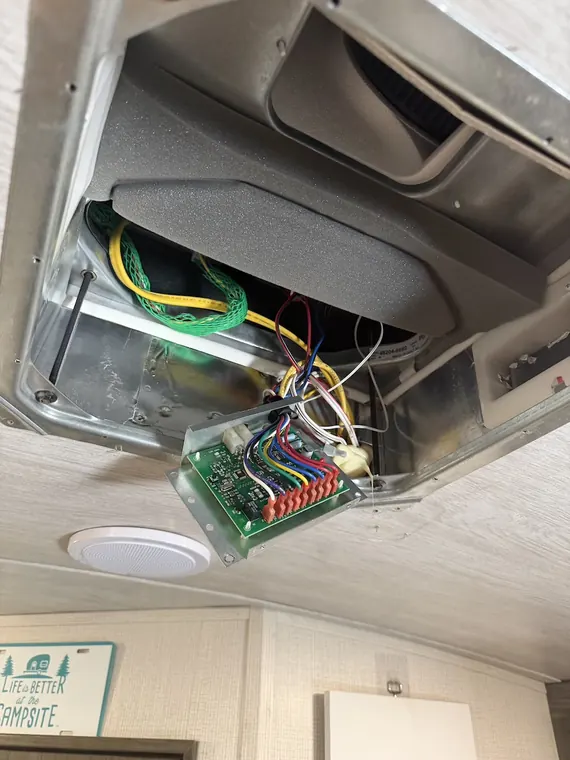 Interior ceiling panel opened to reach 12-volt wiring and a control board