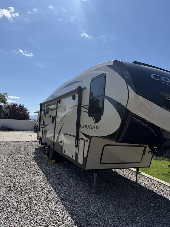 Cougar fifth wheel parked on gravel, ready for service