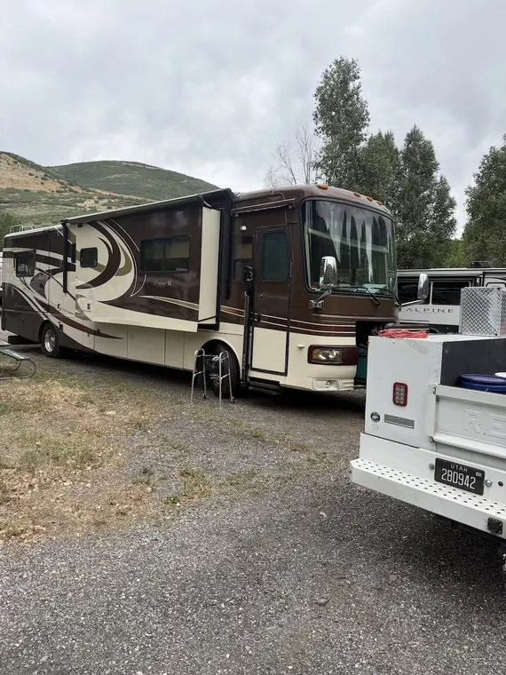 Service truck working alongside a Class A diesel motorhome on site